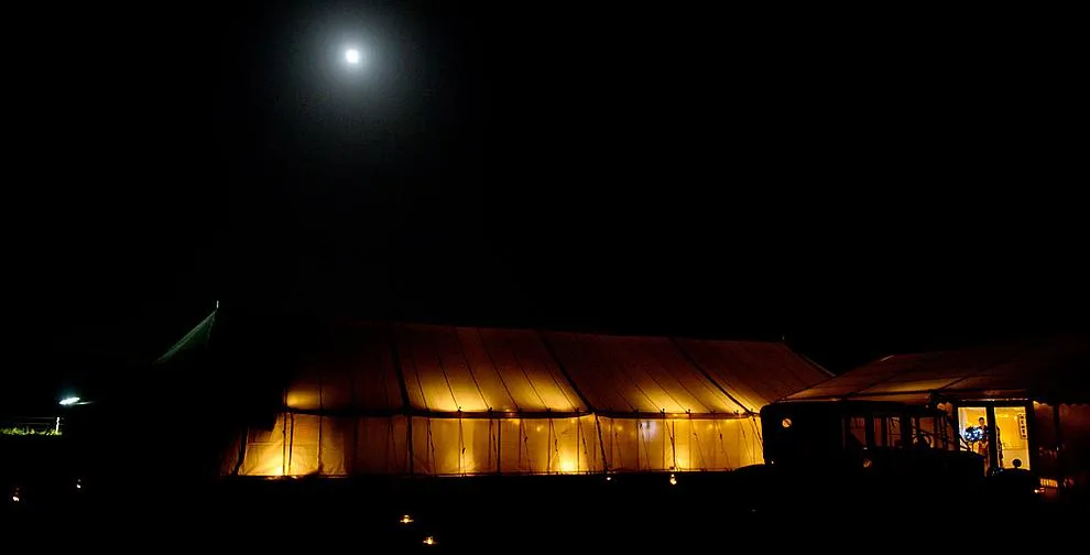 A wedding reception inside a traditional marquee