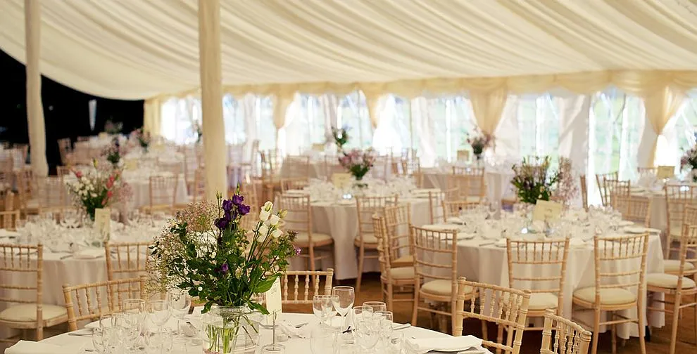 Guests seated at long tables in a traditional marquee