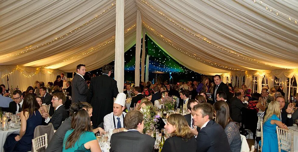 A dressed top table inside a traditional marquee
